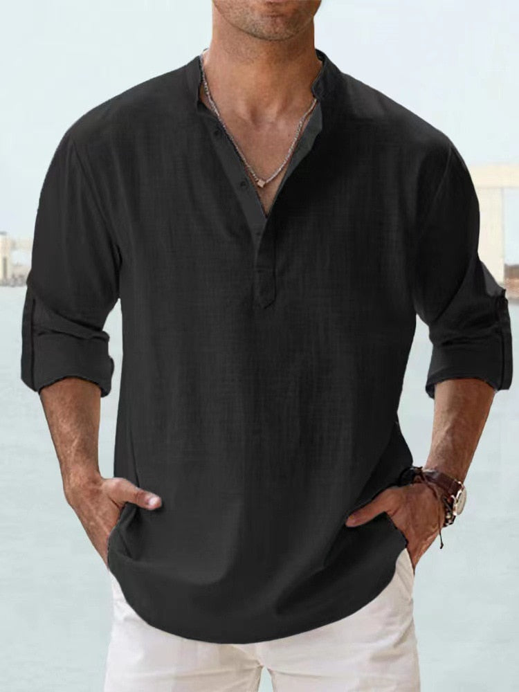 Man wearing a black button-up shirt with rolled sleeves