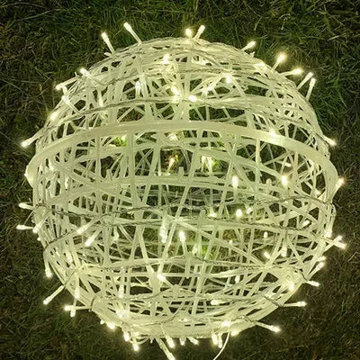 Outdoor garden lighting featuring handmade wicker sphere string lights at dusk