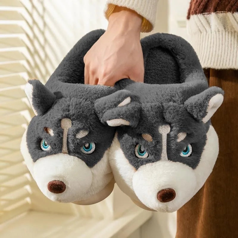 Close-up of dark grey husky plush slippers held up showing detailed embroidery and cute face design.