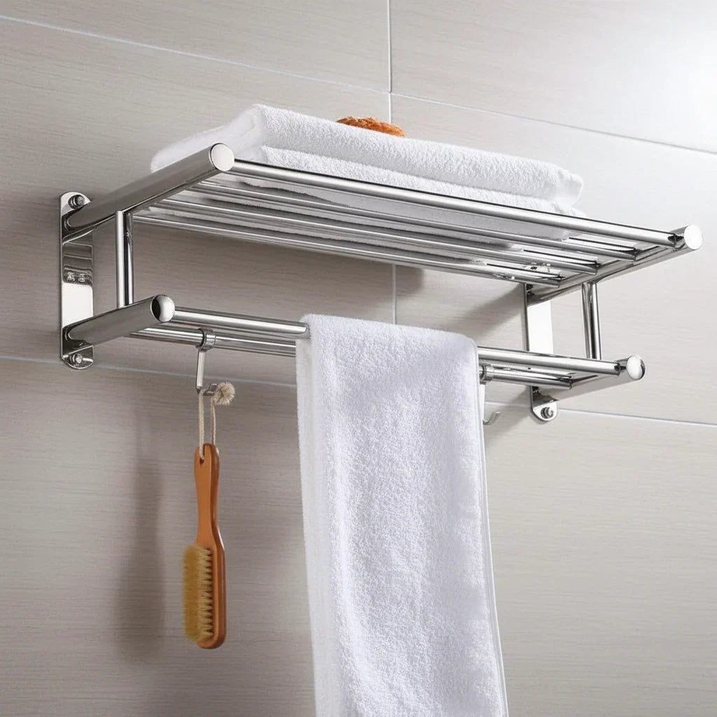 Double tier stainless steel towel rail mounted on tiled wall holding towels and wooden brush