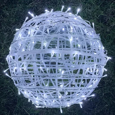Warm white rattan ball lights arranged on a wooden table for wedding decor