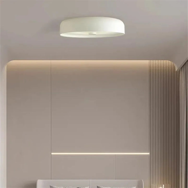 A white minimalist LED ceiling light installed flush against a neutral bedroom ceiling.
