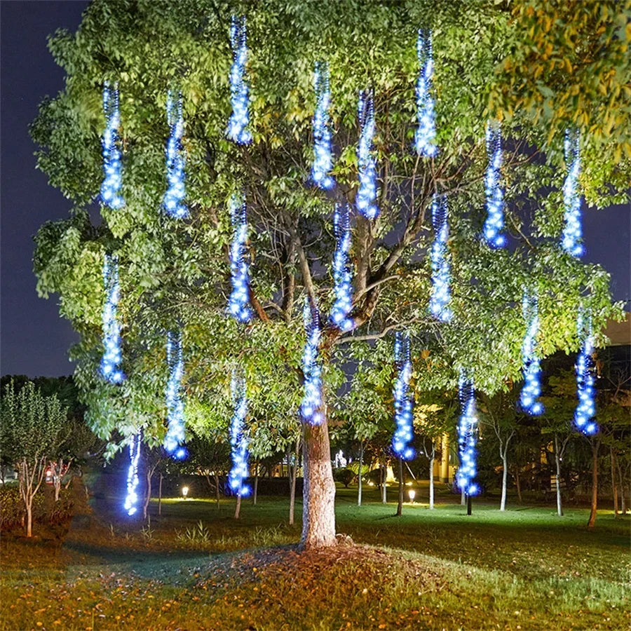 Cometfall blue and white LED string lights illuminating a garden canopy
