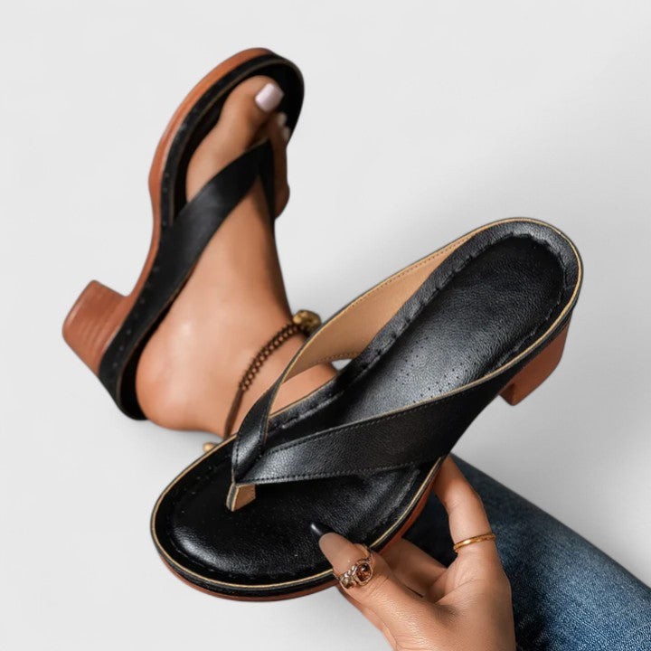Black Talia block heel thong sandal held in hand showing sole detail