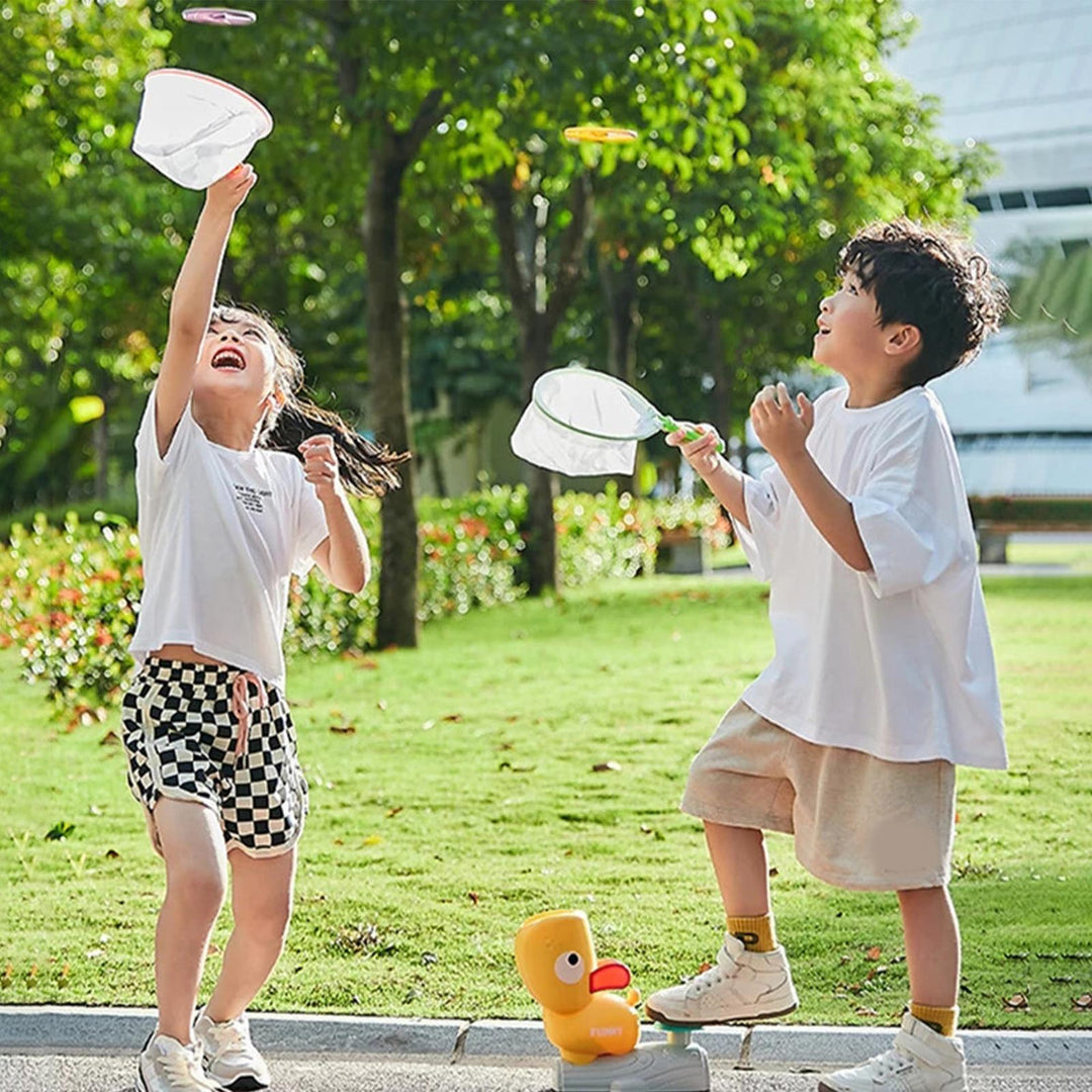 Two children playing outdoors with flying disc launcher and catch nets