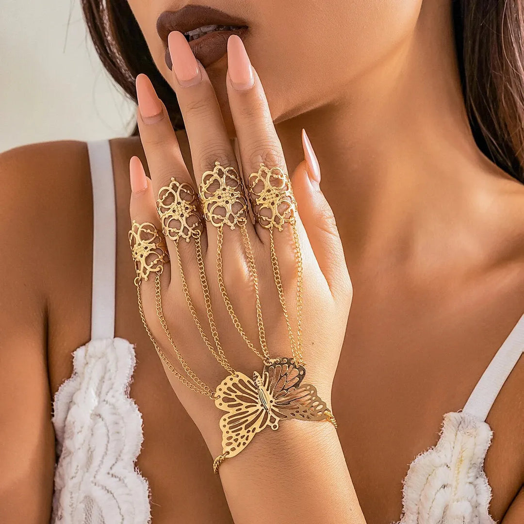 Close-up of women's gold butterfly hand chain and ring set worn on hand