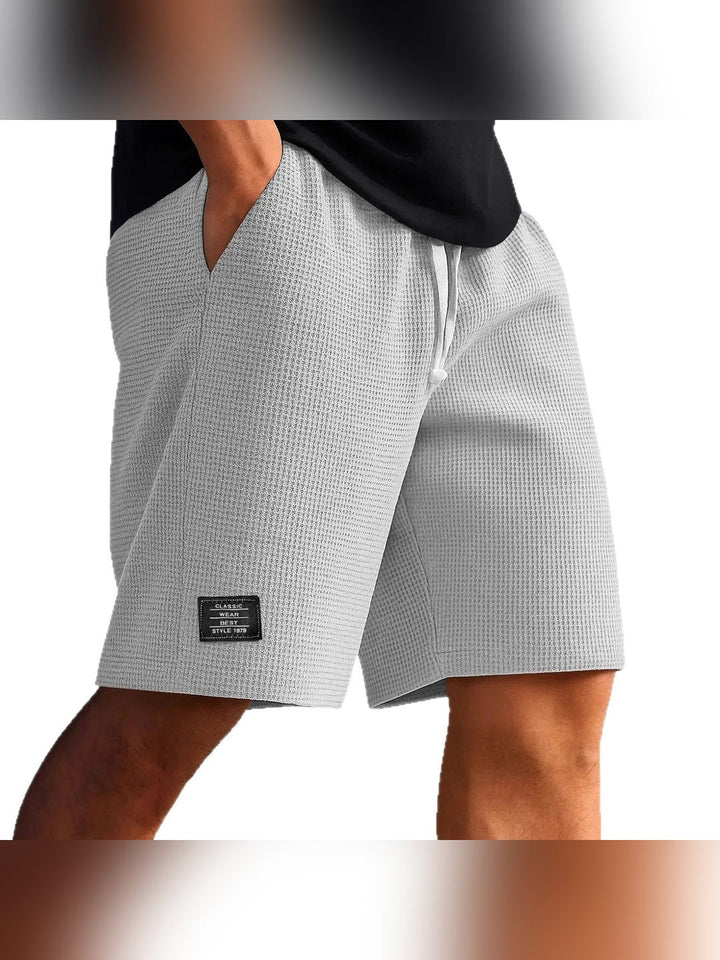 Close-up of hemline and fabric flexibility on men's active shorts