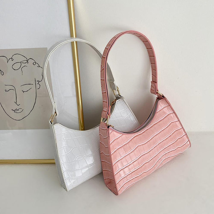 White and pink textured women's shoulder handbags displayed together