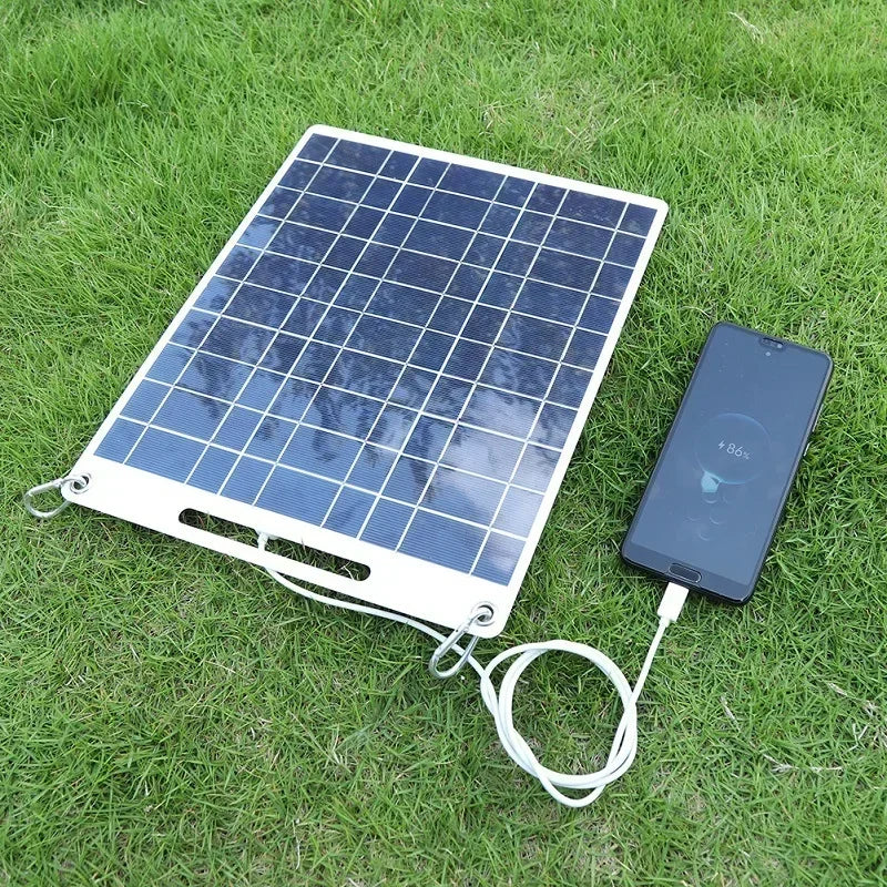 SOLVION 100W portable solar panel charging a smartphone on grass