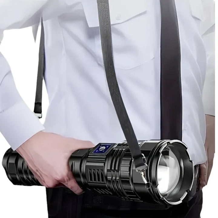 Person holding a heavy-duty rechargeable 10000 lumen black LED flashlight with a shoulder strap.