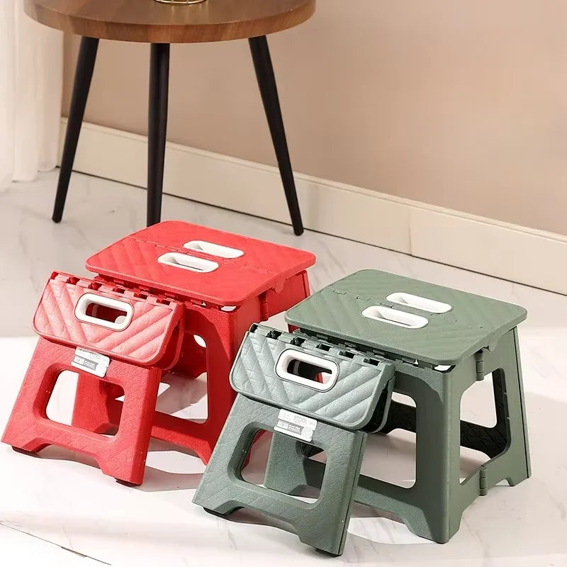 Red and green folding step stools displayed on a white floor