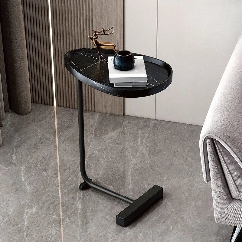 C-shaped end table used in the living room holding a cup of coffee and a book