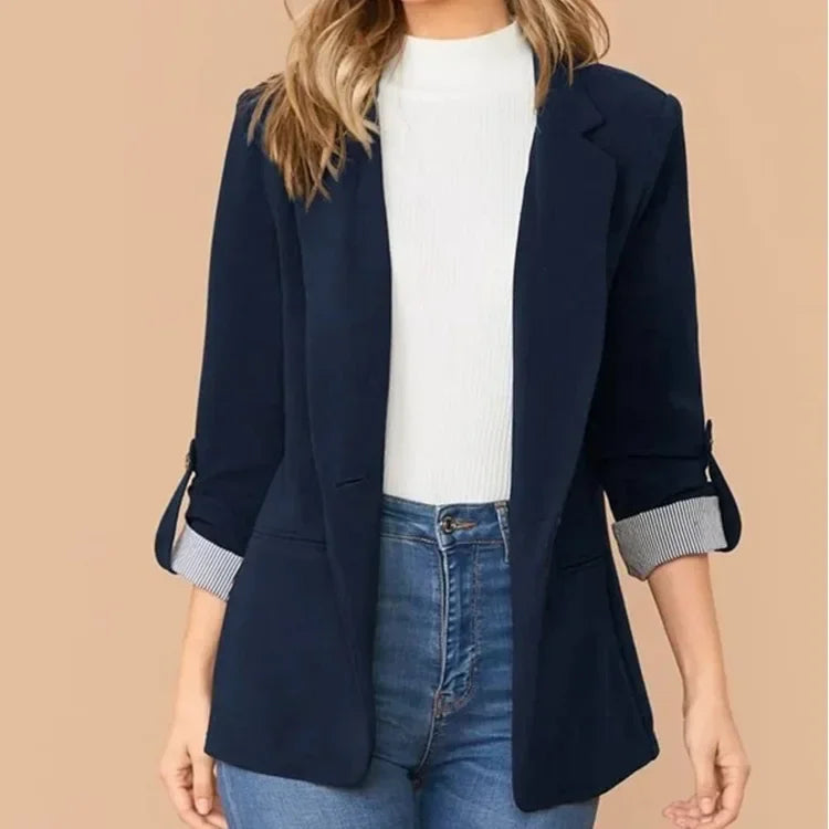 Studio shot of navy blazer worn over white top and denim jeans