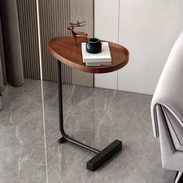 Nirethia C-shaped mobile side table featuring a black frame and walnut wooden top in a modern living room