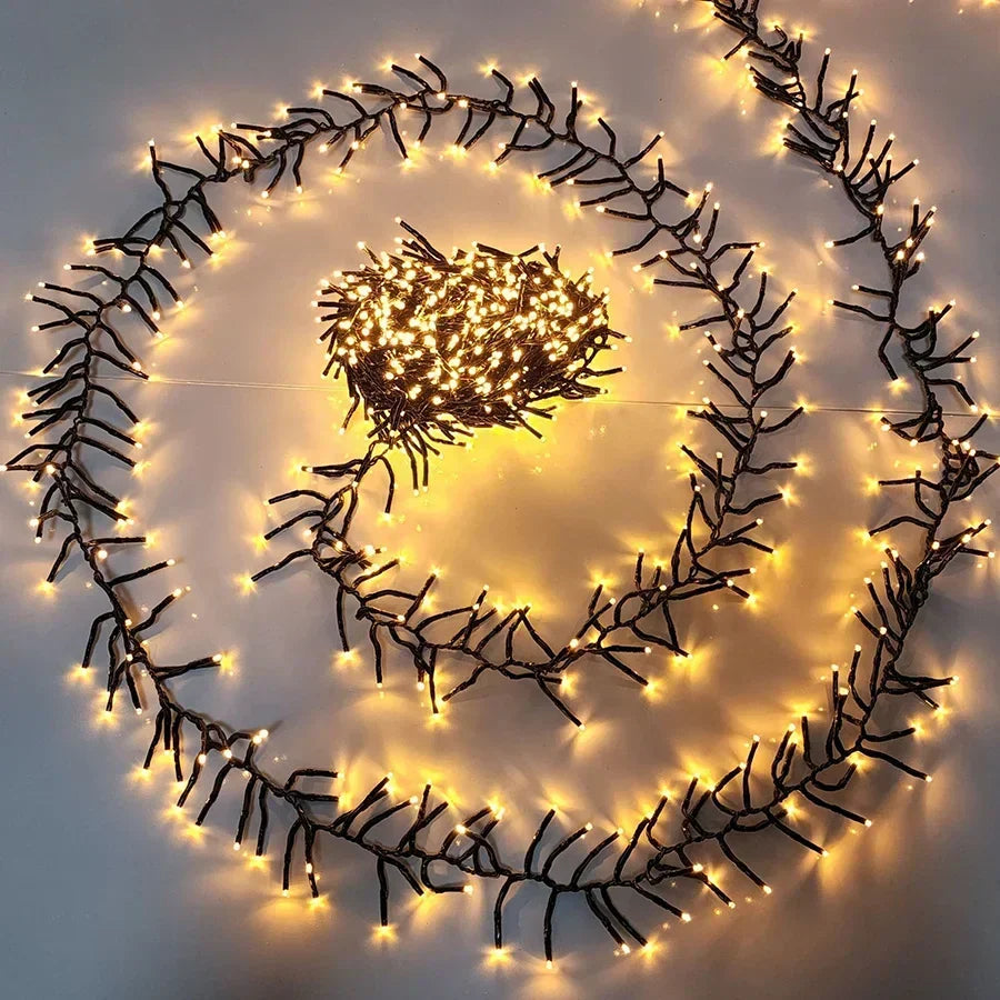Coiled Halcyon festive LED string lights glowing warmly on a white surface