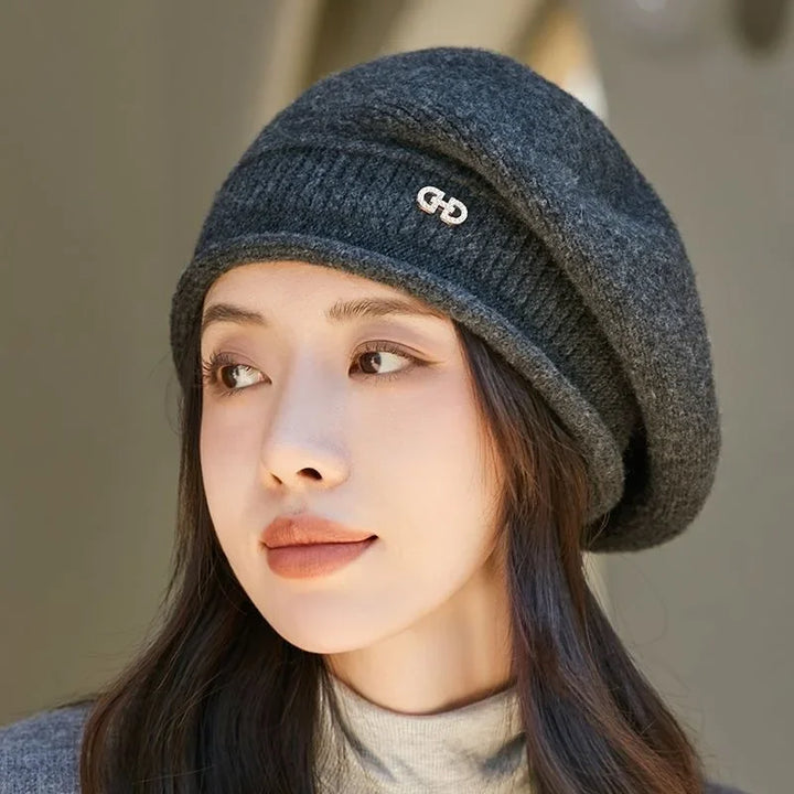 Woman wearing a dark charcoal grey knit beret accessory