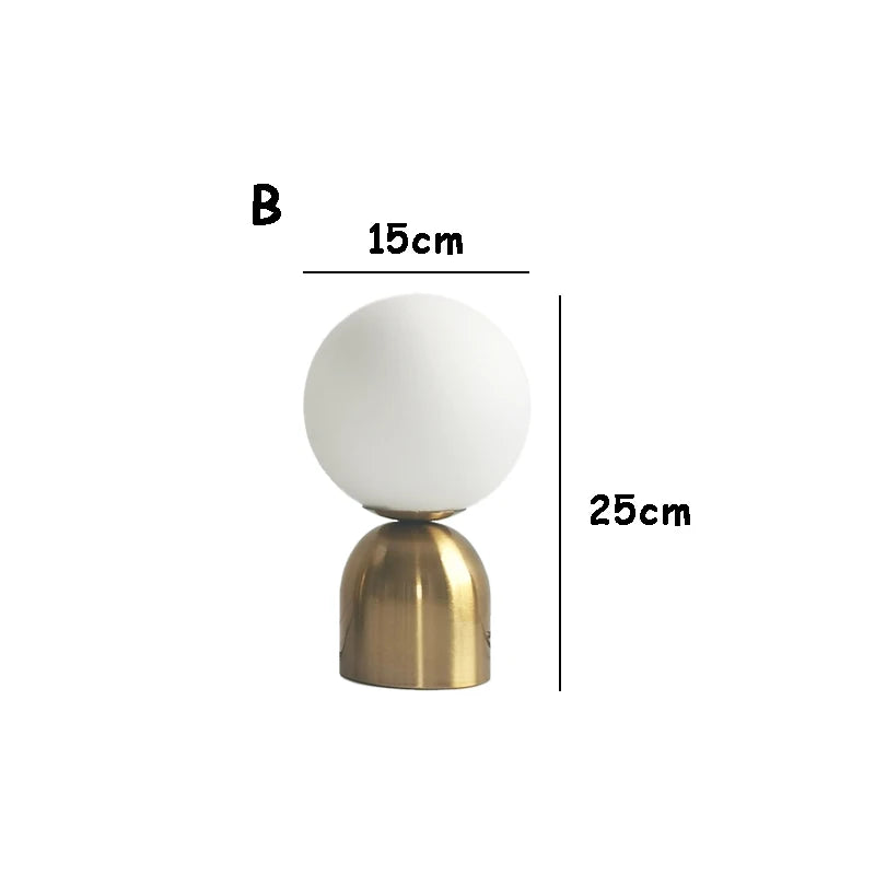 Minimalist brass and glass table lamp lit up, highlighting nordic design.
