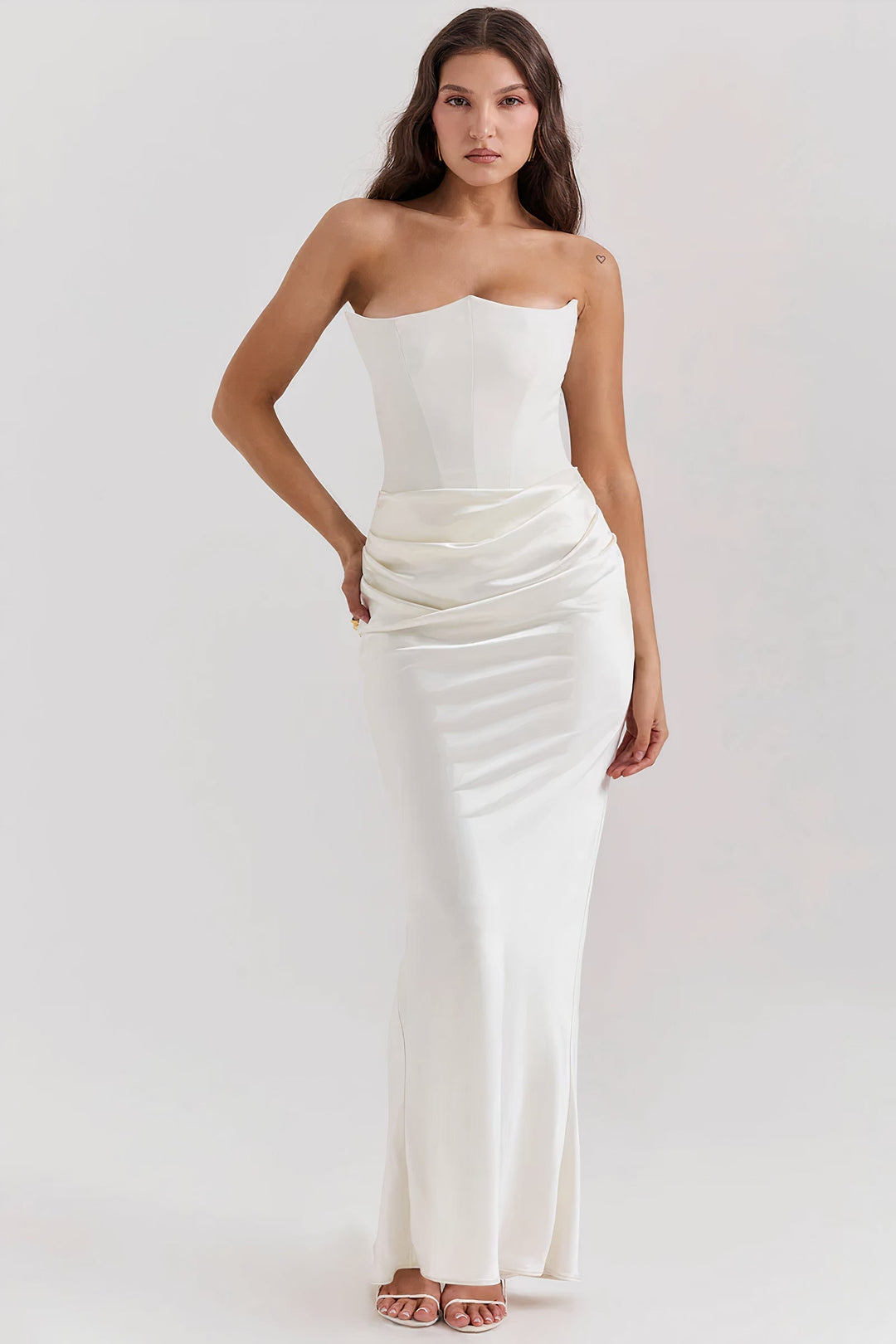 Front view of a woman wearing an elegant white strapless corset dress