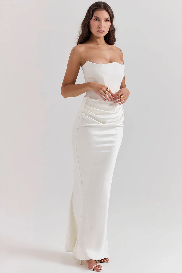 Three-quarter view of a woman posing in a stunning white strapless corset maxi dress