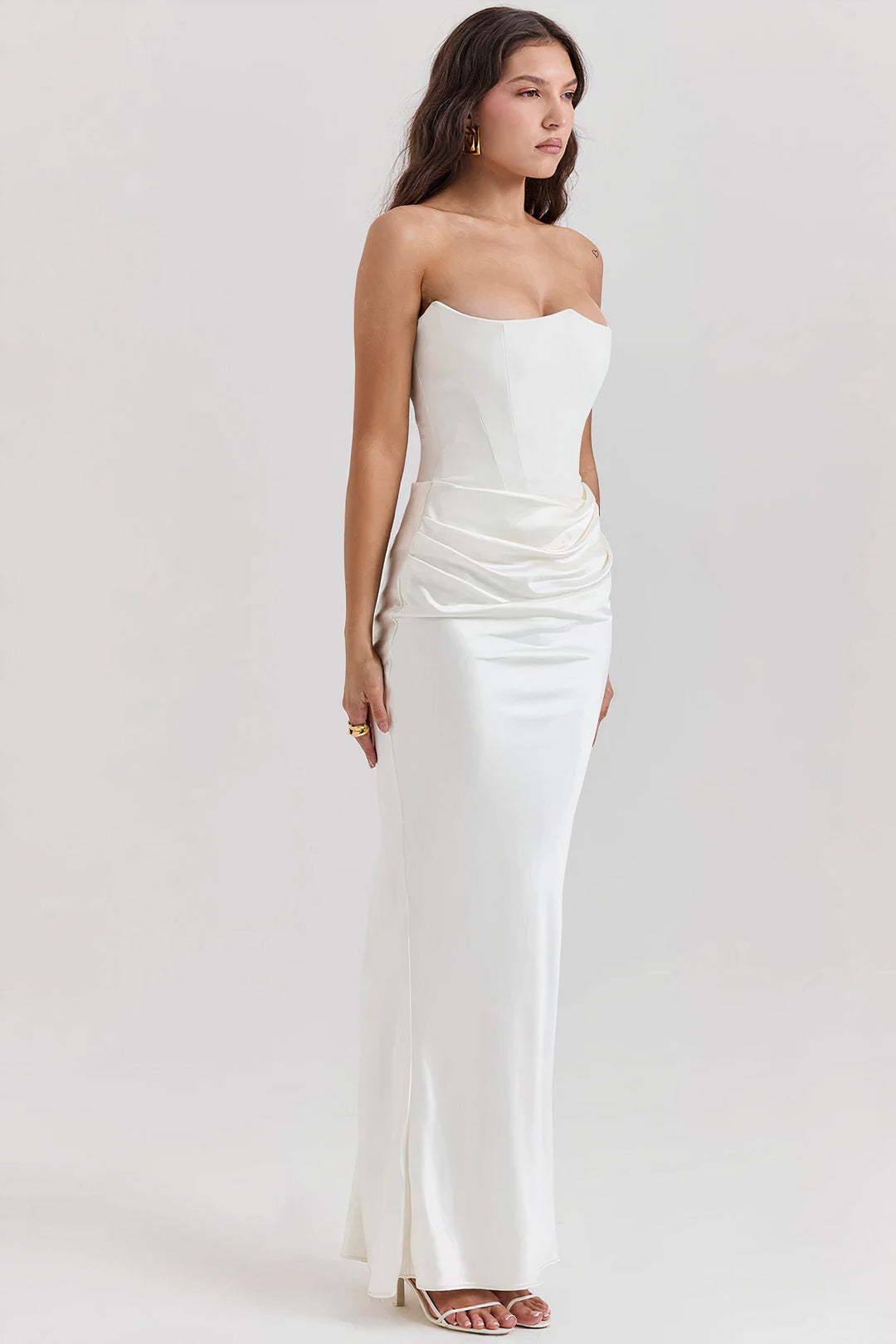 Side profile of a model showcasing the fit of the white strapless corset dress