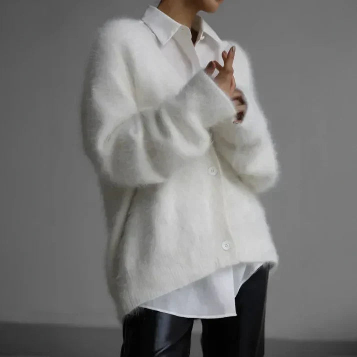 Woman styled in a white soft knit cardigan over a collared shirt