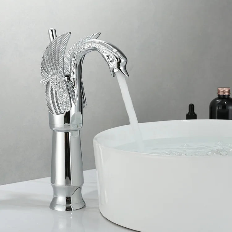 Tall chrome swan basin tap mounted beside a white ceramic sink
