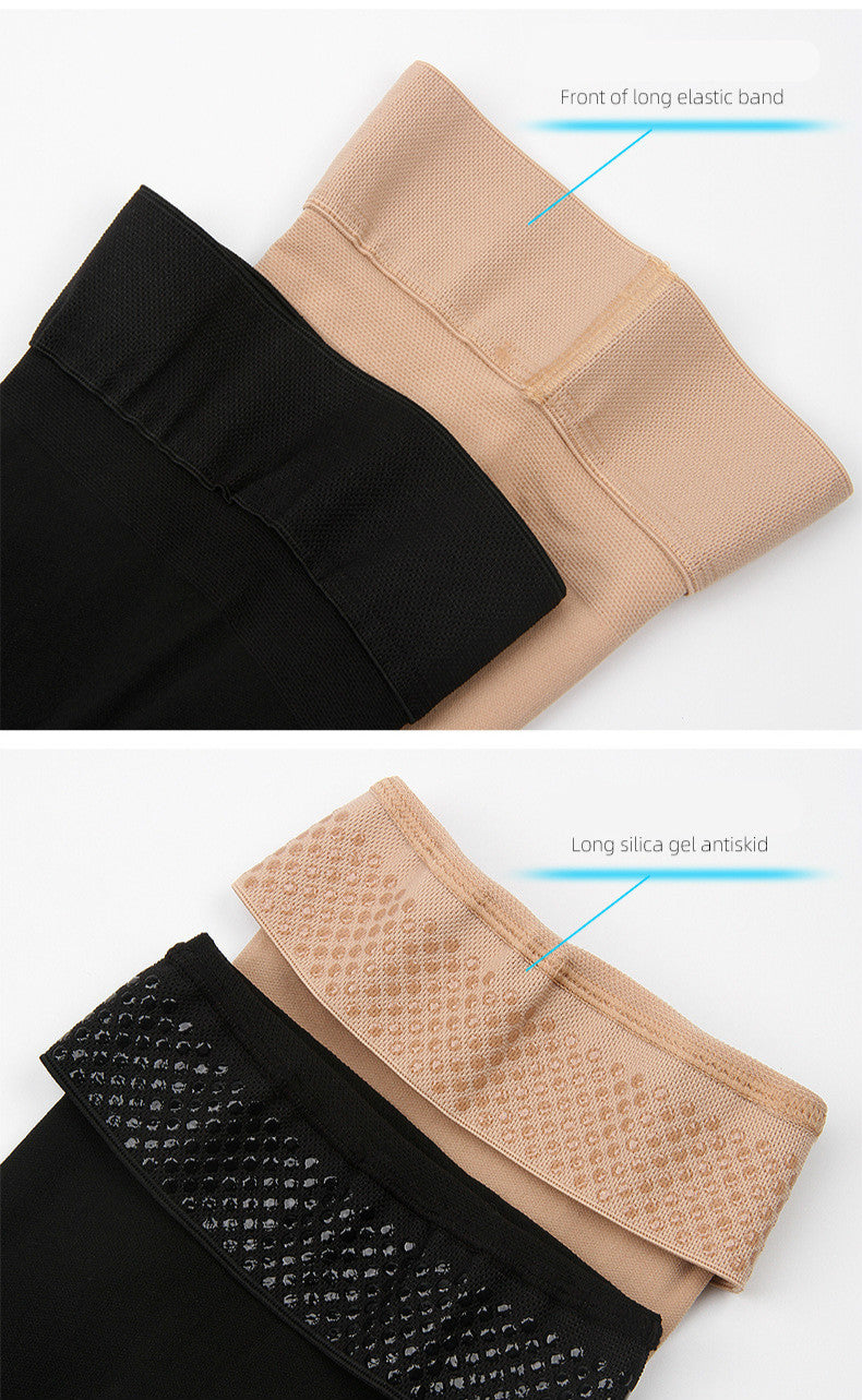 Pair of black unisex thigh high support socks laid flat on white surface