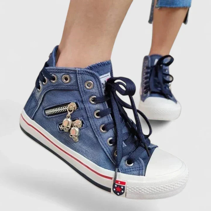 Close-up of navy blue high top denim sneaker with zip and skull charm details