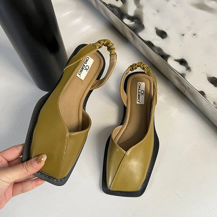 Close-up of olive green square toe slingback sandals held in hand