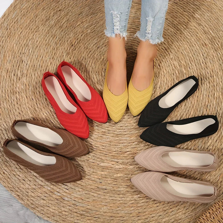 Assorted colors of women's casual breathable ballet loafers displayed together on a round woven mat