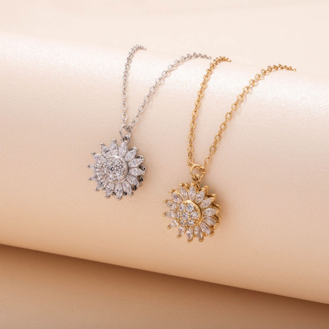 Gold and silver rotating sunflower pendant necklaces displayed together