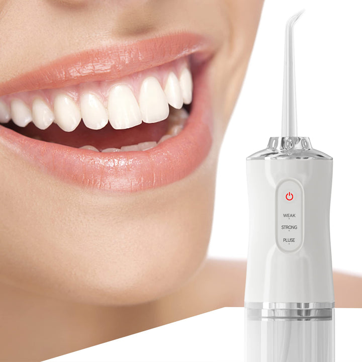 Close-up of a smiling person next to the white electric oral irrigator unit