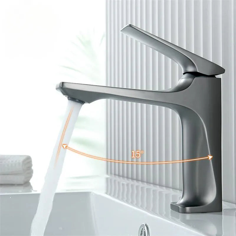 Single-handle basin mixer faucet operating with water stream over a white sink