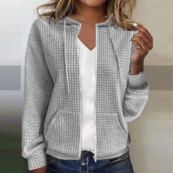 Woman wearing grey textured zip-up hooded jacket with adjustable drawstrings
