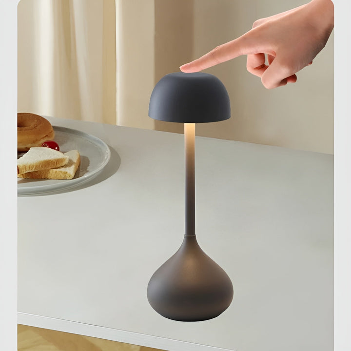 Modern wireless LED bedside lamp casting warm ambient glow on wooden desk
