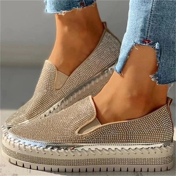 Close-up of golden slip-on walking loafers worn with denim