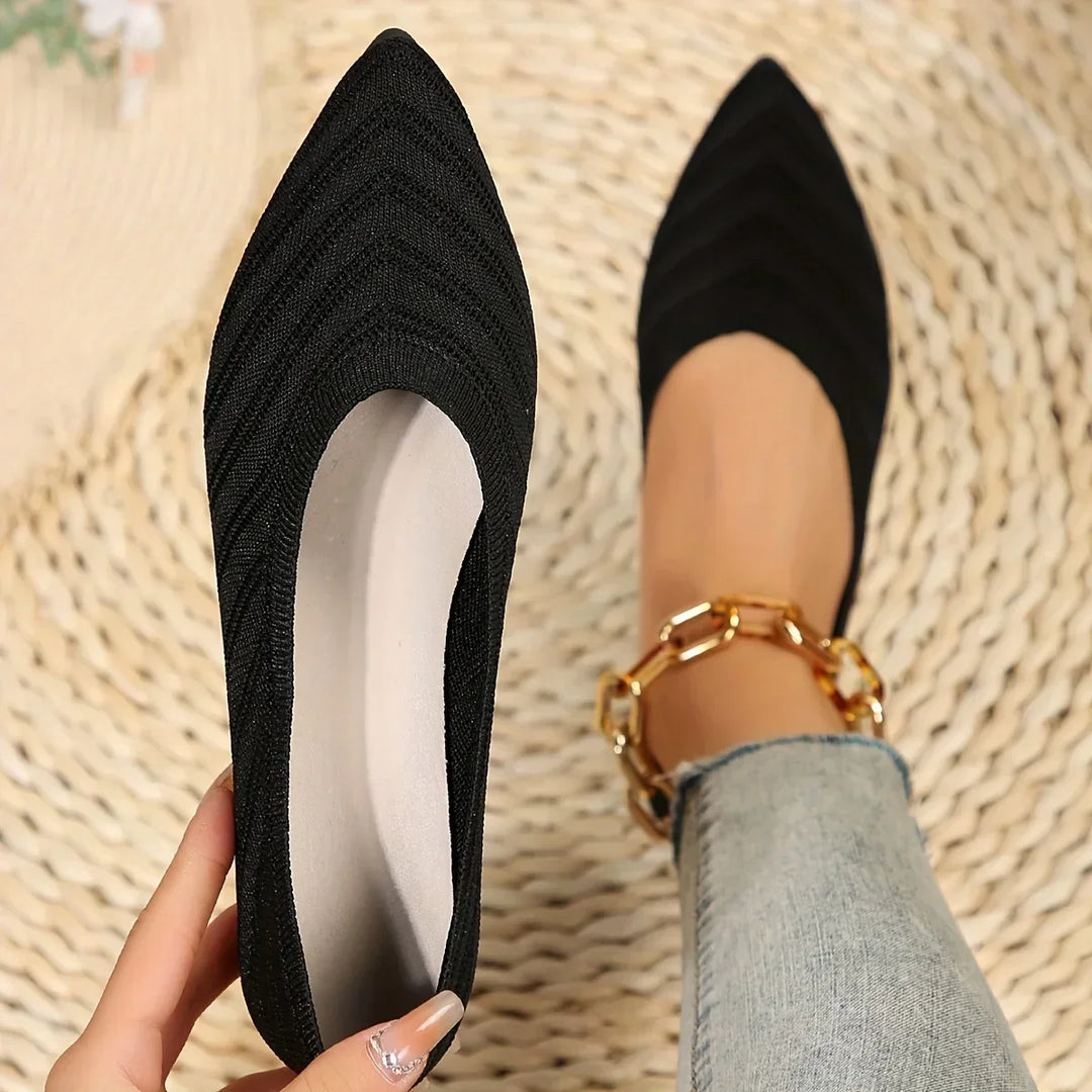 Close-up view of black pointed toe knitted slip-on ballet loafers held in hand