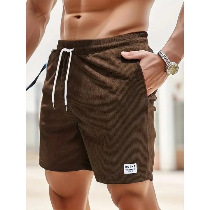 Folded stack of stylish summer shorts for men in various neutral colors