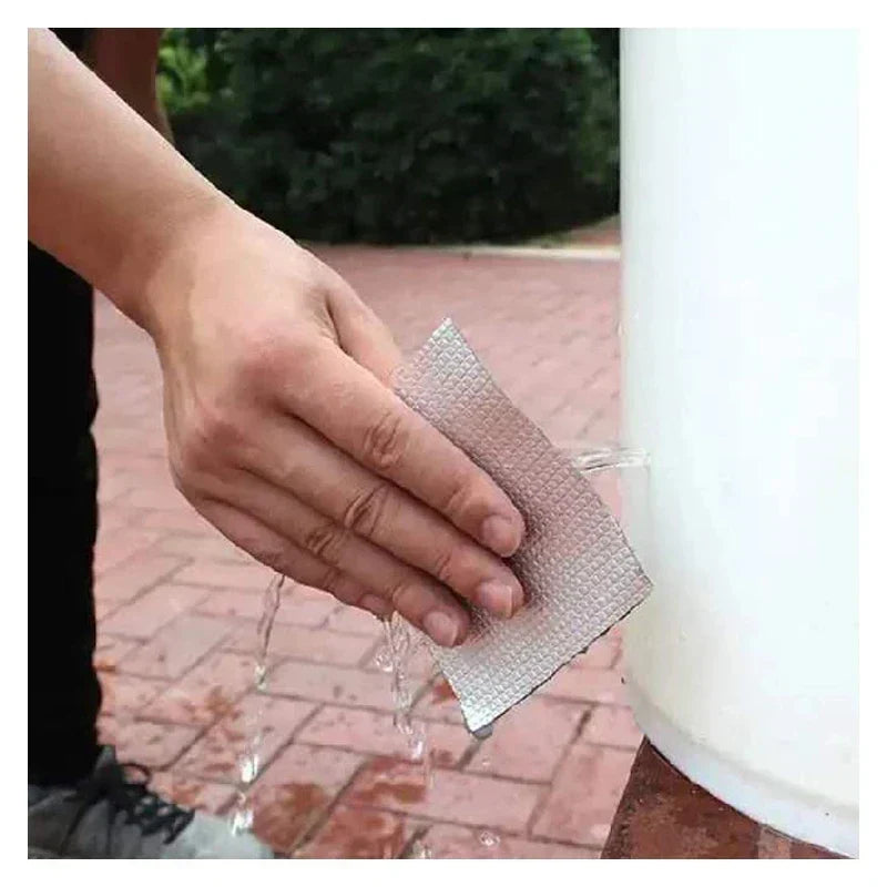 Person applying silver waterproof butyl tape to a leaking container