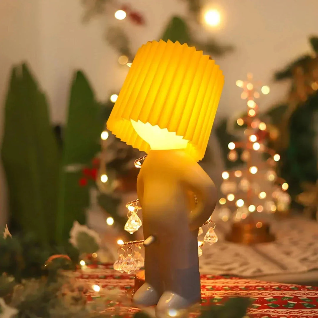 Yellow playful LED character table lamp glowing warmly on a festive table setting