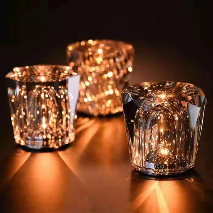Three crystal table lamps glowing on a dark table surface
