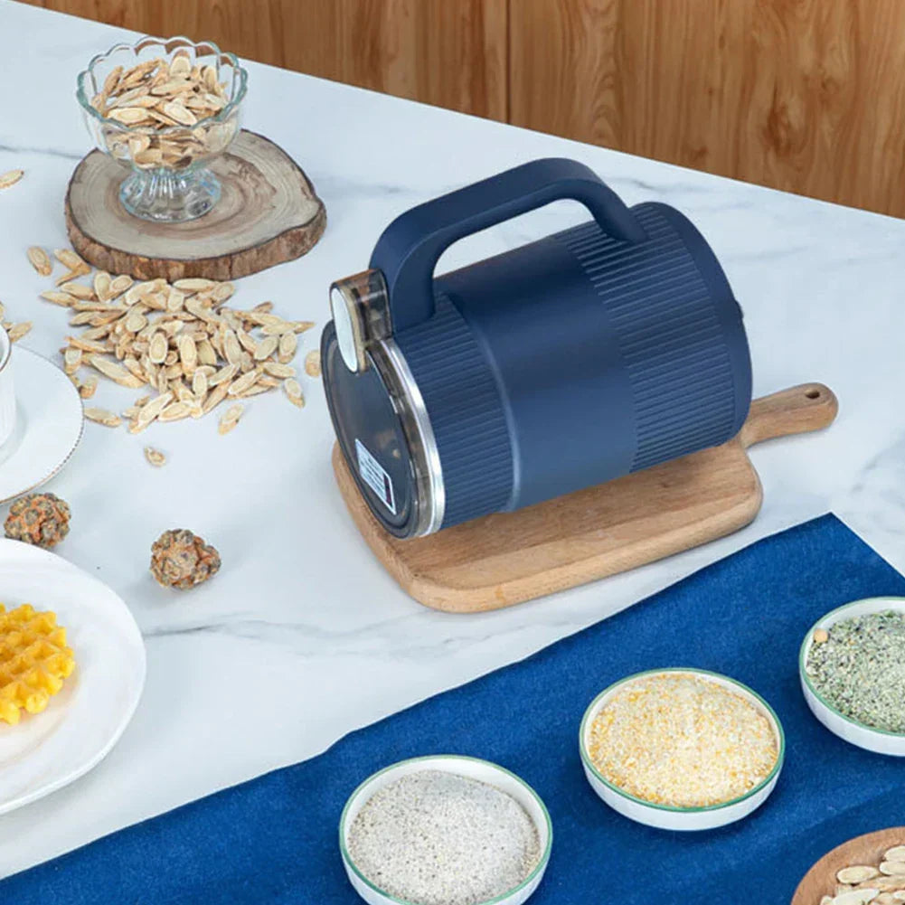 Blue compact electric spice grinder laid sideways on a wooden cutting board
