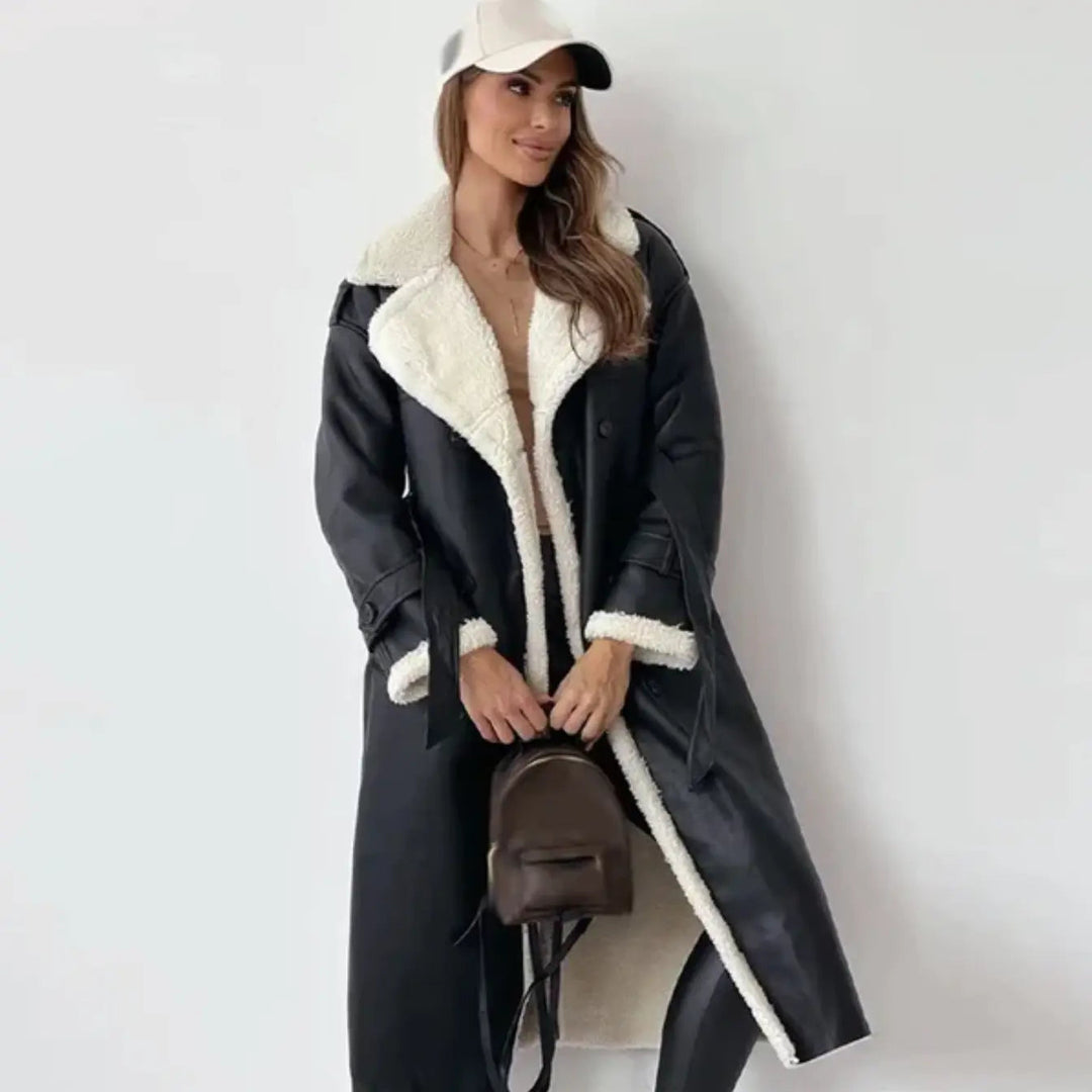 Woman wearing a black long winter coat with a plush teddy collar and belt