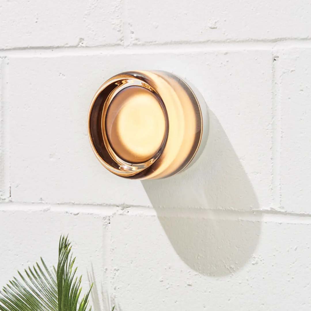 Amber DimpleGlow modern wall lamp mounted on a white brick wall