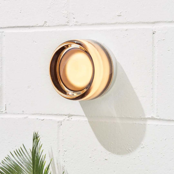 Amber DimpleGlow modern wall lamp mounted on a white brick wall