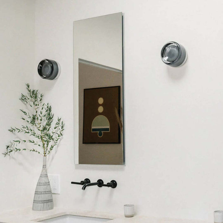 Smoke and white DimpleGlow wall lamps mounted in a modern bathroom setup