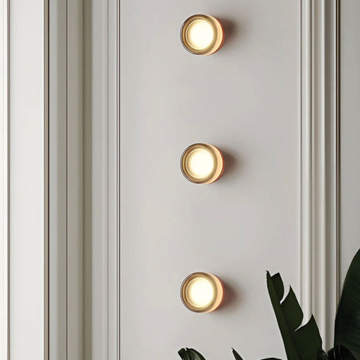 Multiple DimpleGlow wall lamps installed vertically on a hallway wall