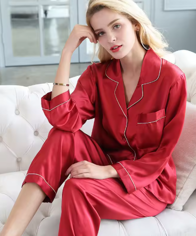 Woman wearing red two-piece sleepwear set on a white sofa