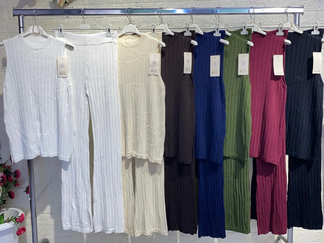 Hanging display of various colored ribbed two-piece lounge sets on a clothing rack