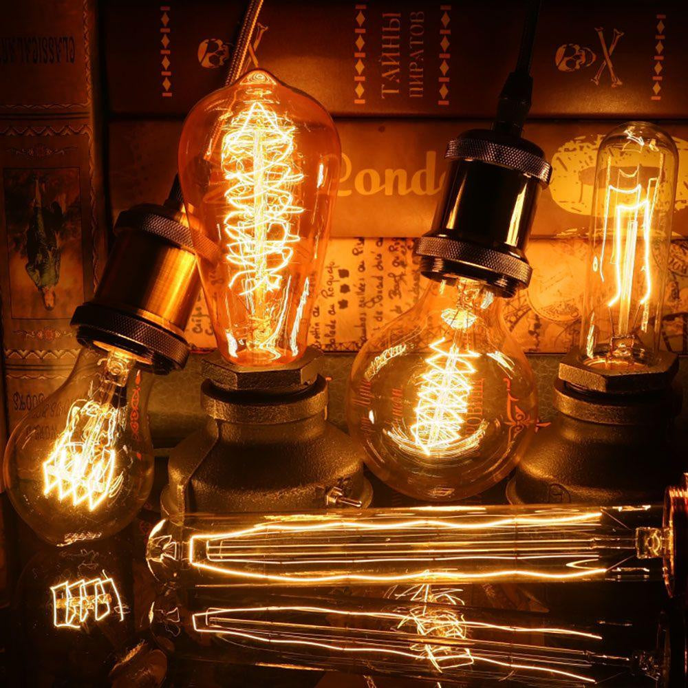 Assorted vintage Edison light bulbs glowing on a dark rustic background